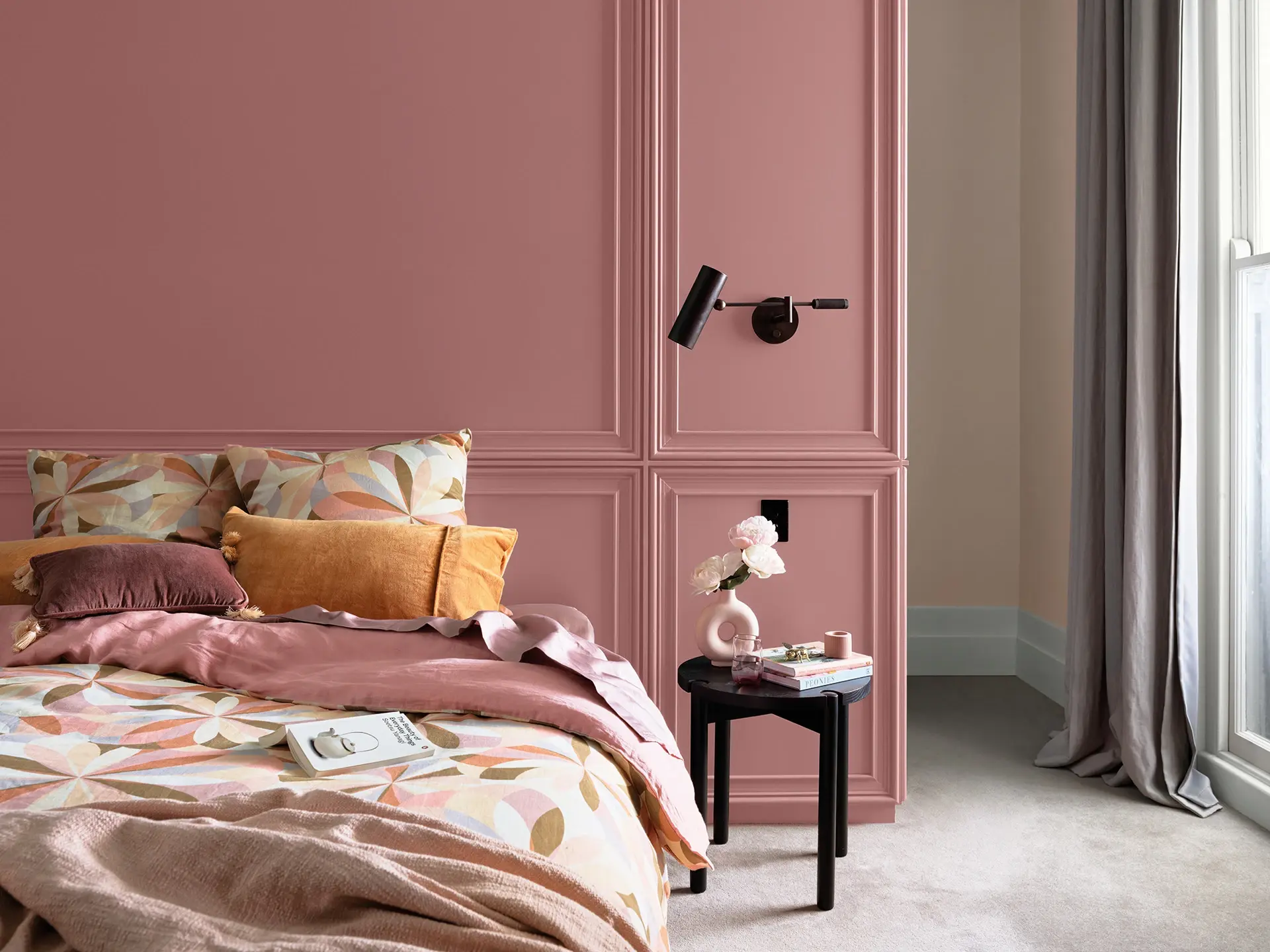 Bedroom with pink wall, pink and orange bedding and neutral carpet and curtains
colour: Terra Rose
