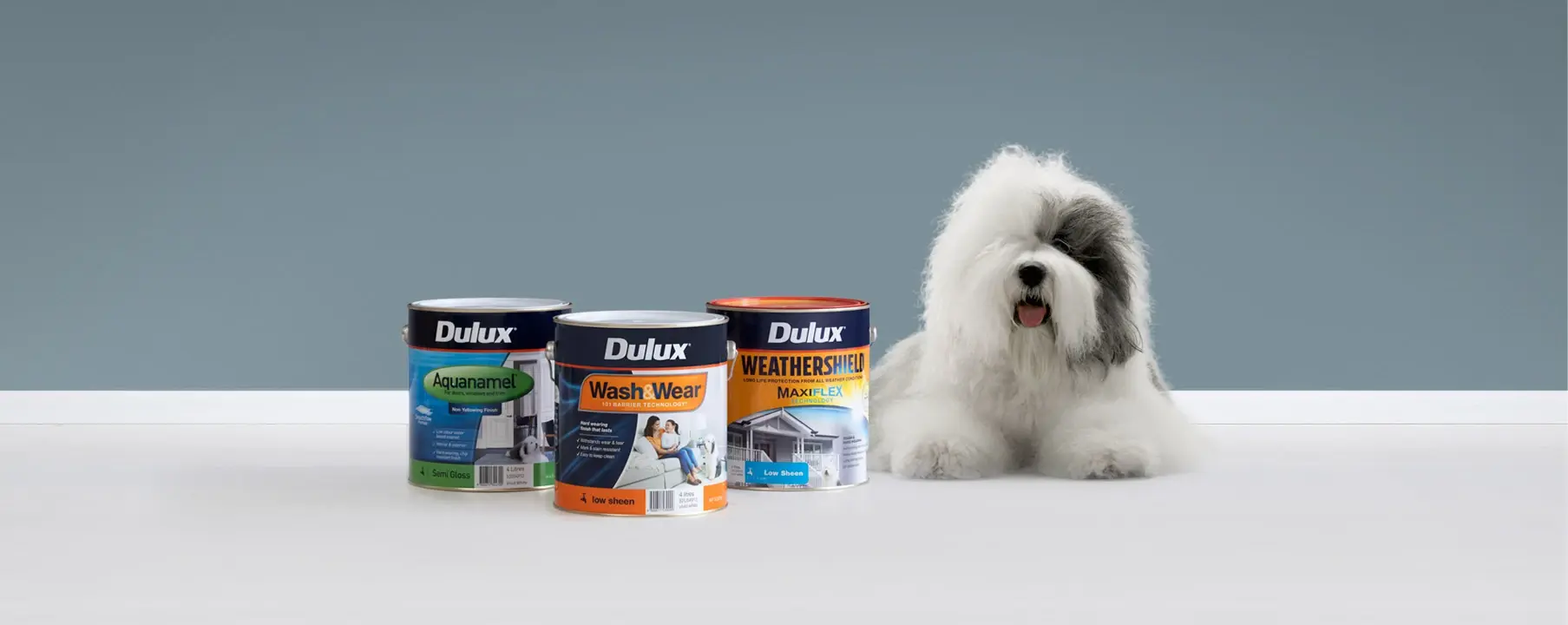 Dulux dog with Wash&Wear, Weathershield and Aquanamel paint tins.